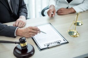 A professional male lawyer or counselor discussing a legal case with a client, reviewing a contract document in an office setting, focusing on law and justice. 