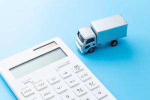 A truck and a calculator placed on a blue background.