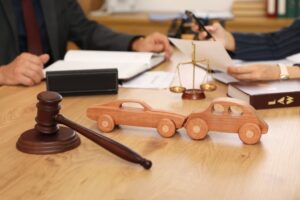 Wooden cars with judge's gavel on lawyer's table during meeting in office